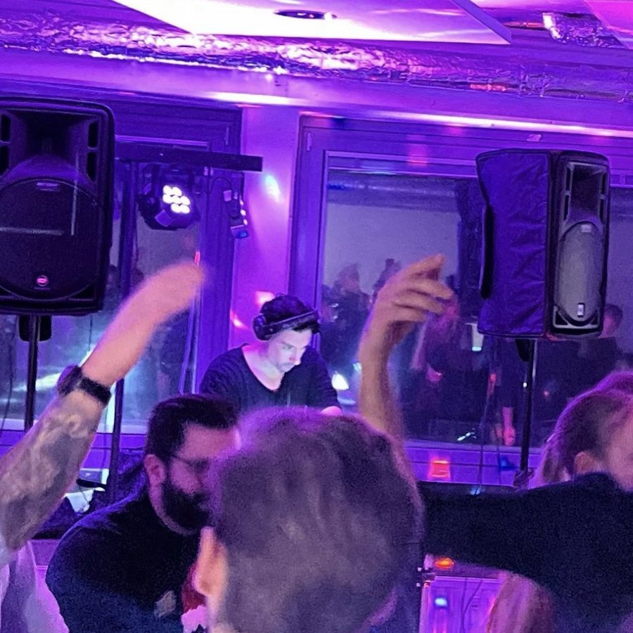 Tanzende Gäste vor der Bühne, im Hintergrund Jenson am DJ-Pult
