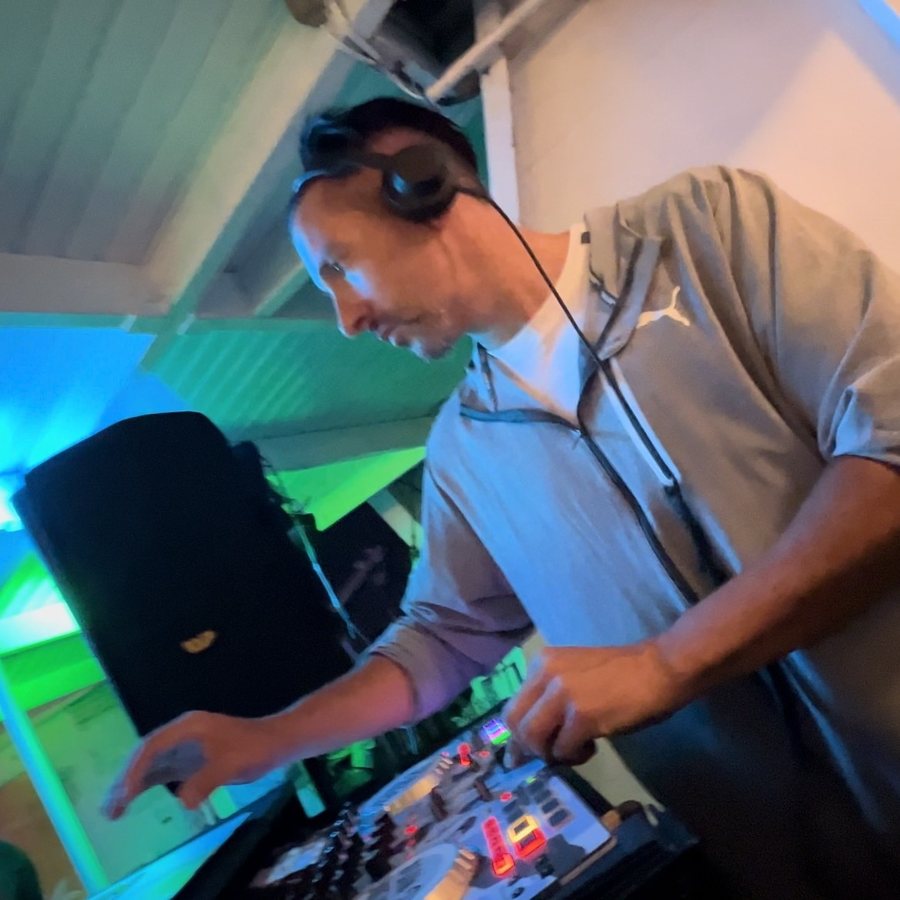 Jenson beim DJ-Set an den Reglern, Bühnenlicht im Hintergrund